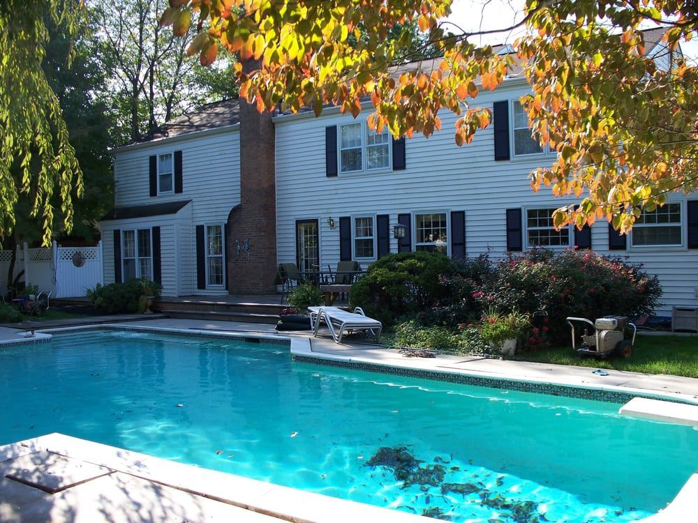 A large house with a large swimming pool in front of it