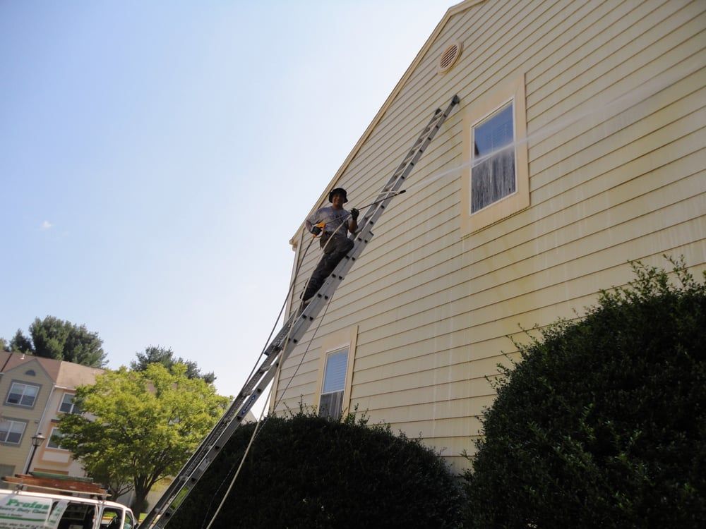 A man standing on a ladder on the side of a building