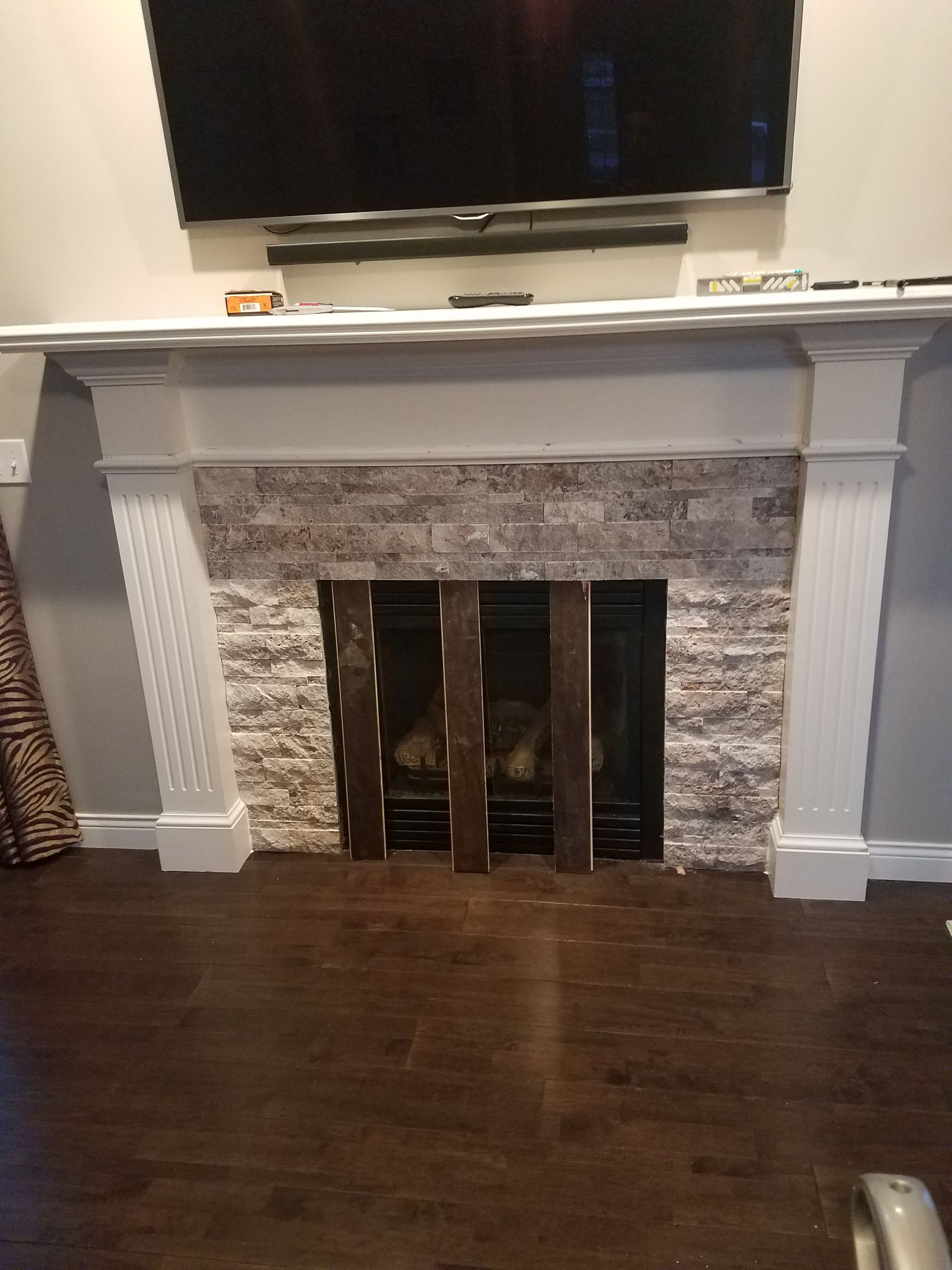 A living room with a fireplace and a flat screen tv.