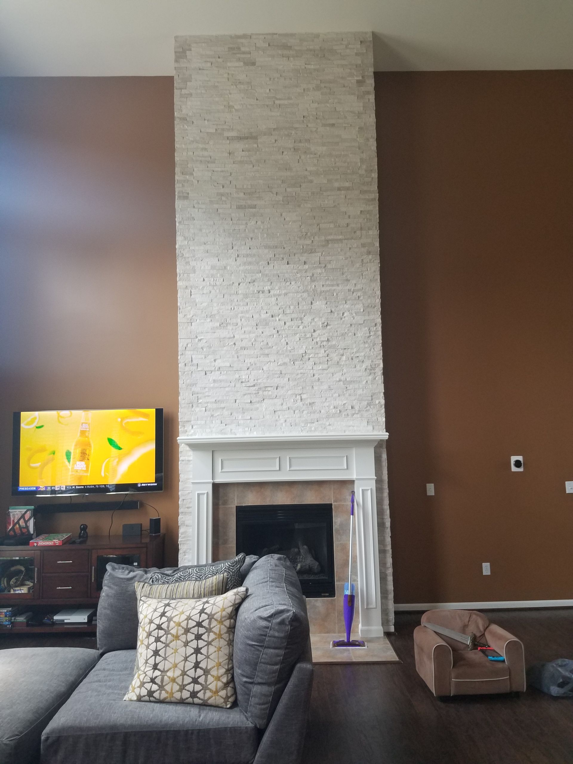 A living room with a fireplace , couch , and television.