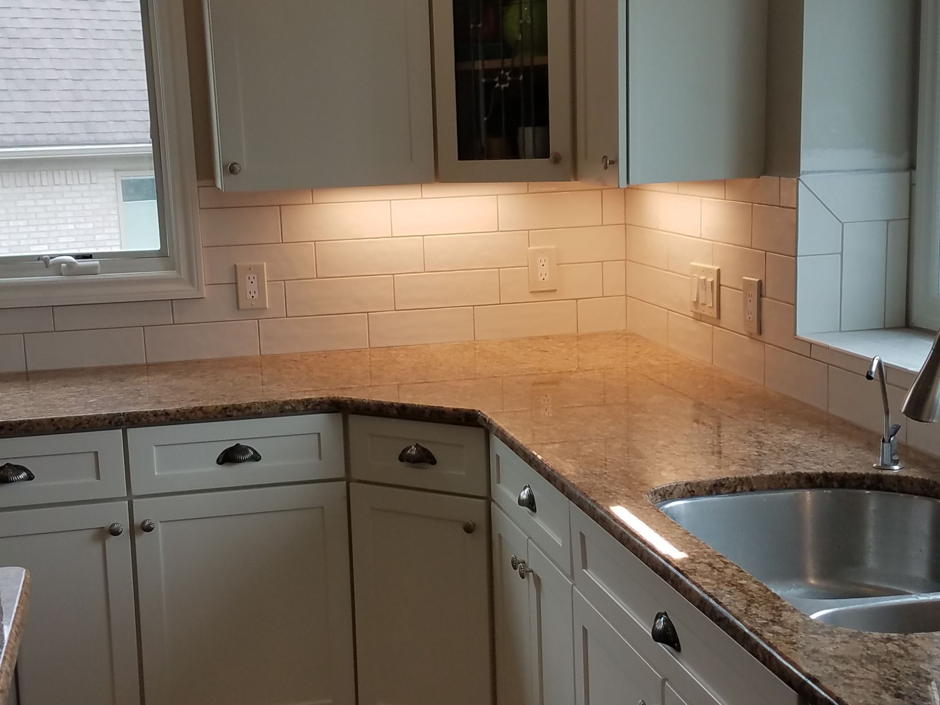 A kitchen with granite counter tops and white cabinets