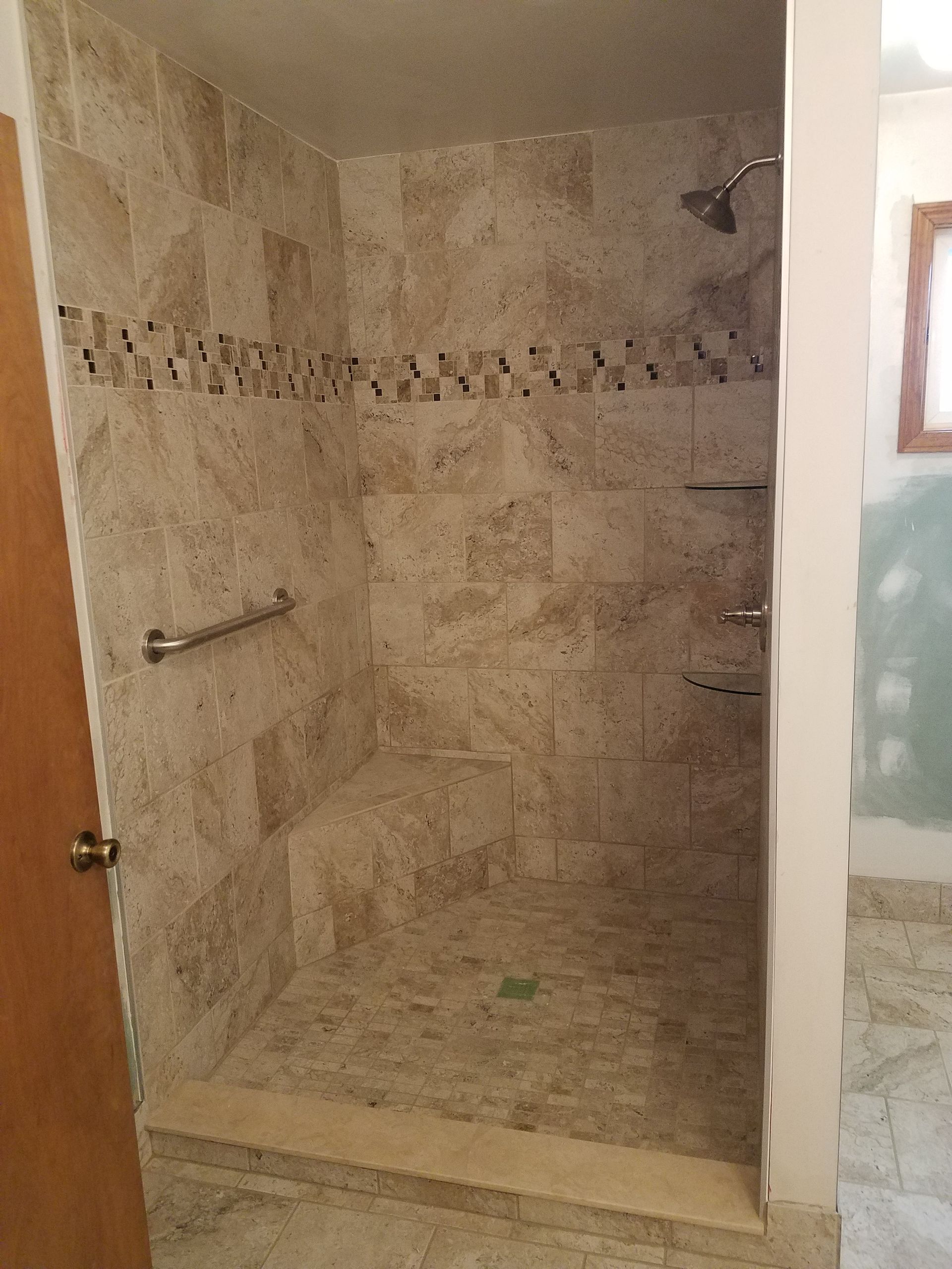 A bathroom with a walk in shower and a door.
