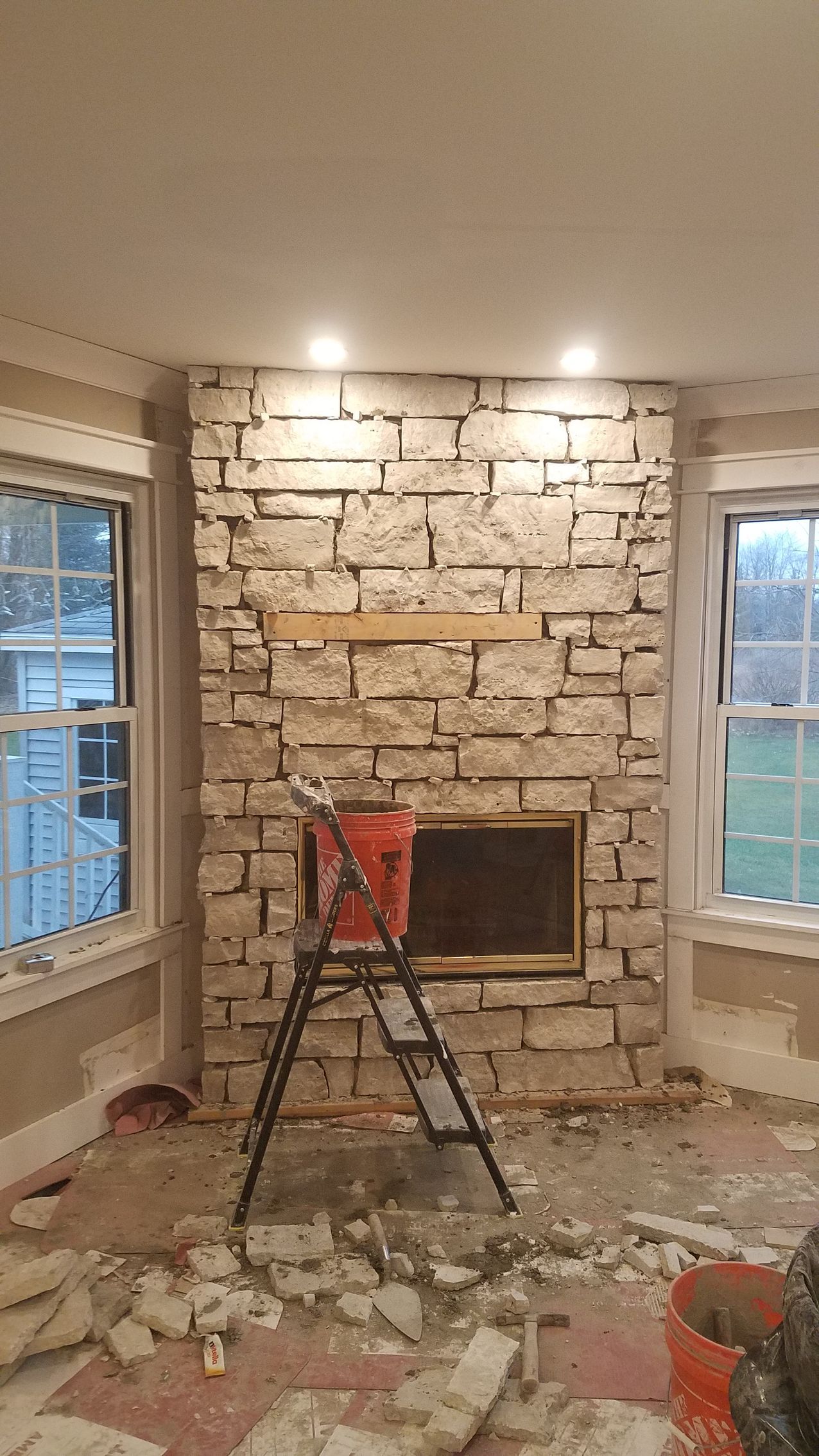 A room with a fireplace and a ladder in it.