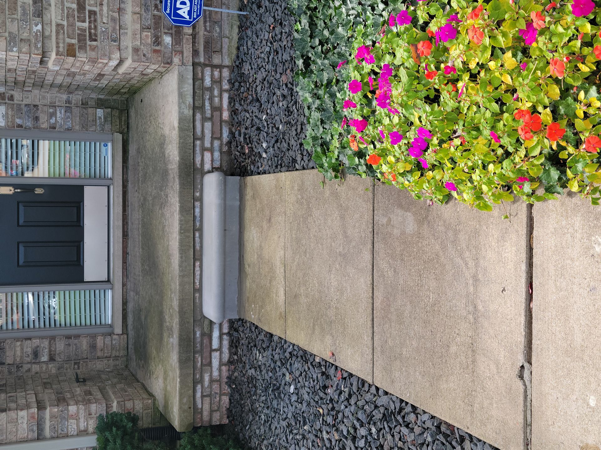 A brick house with a black door and a walkway leading to it.