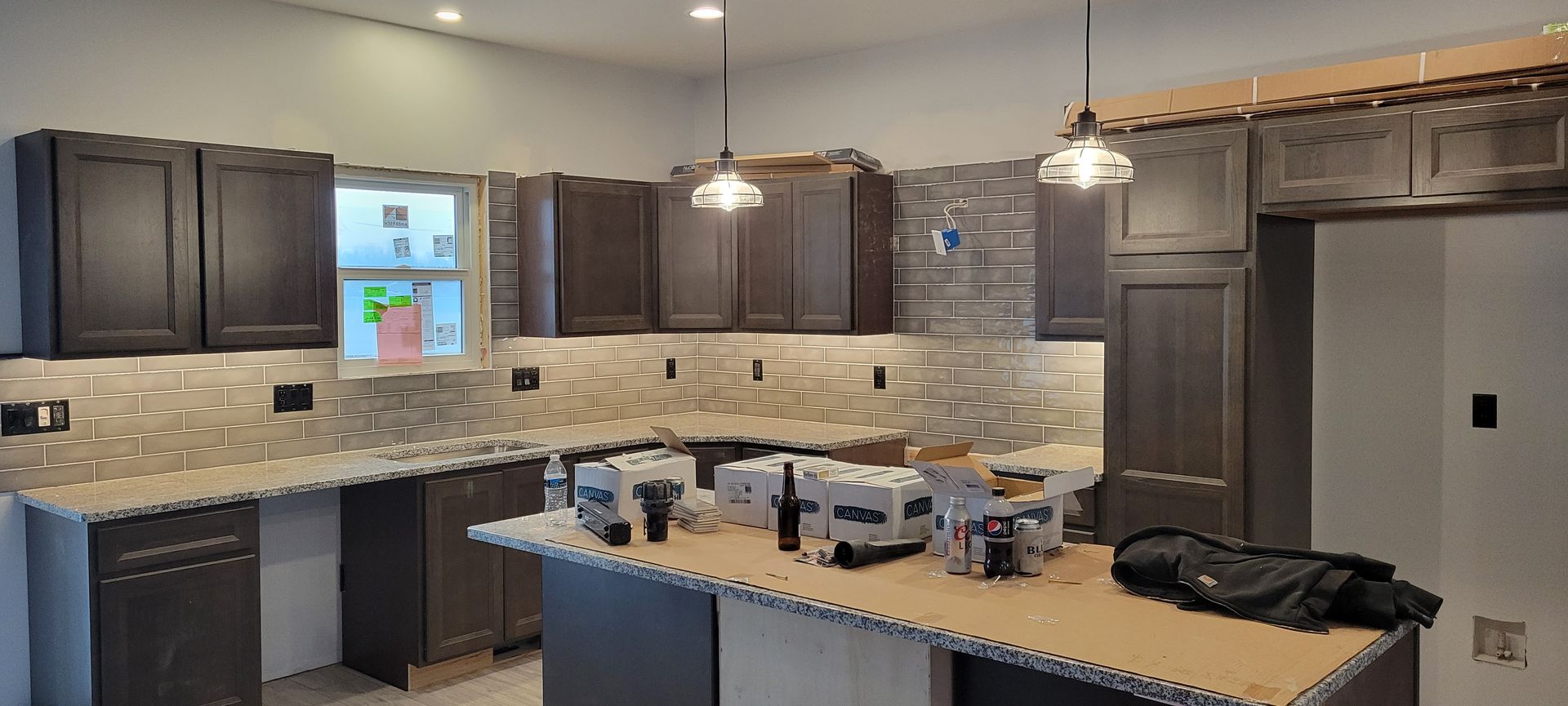 A kitchen with a lot of cabinets and counter tops is being remodeled.
