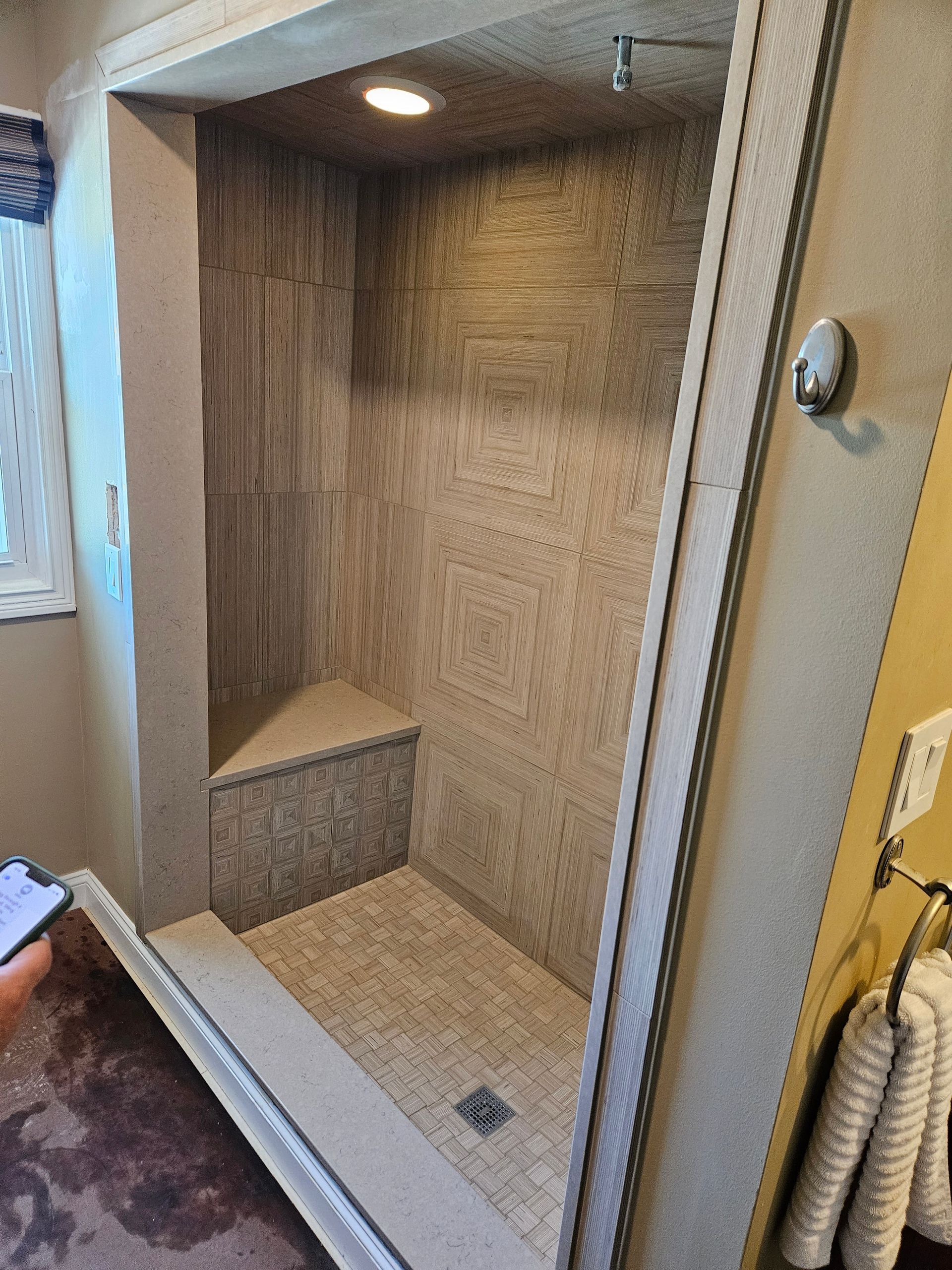 A bathroom with a walk in shower and a window.