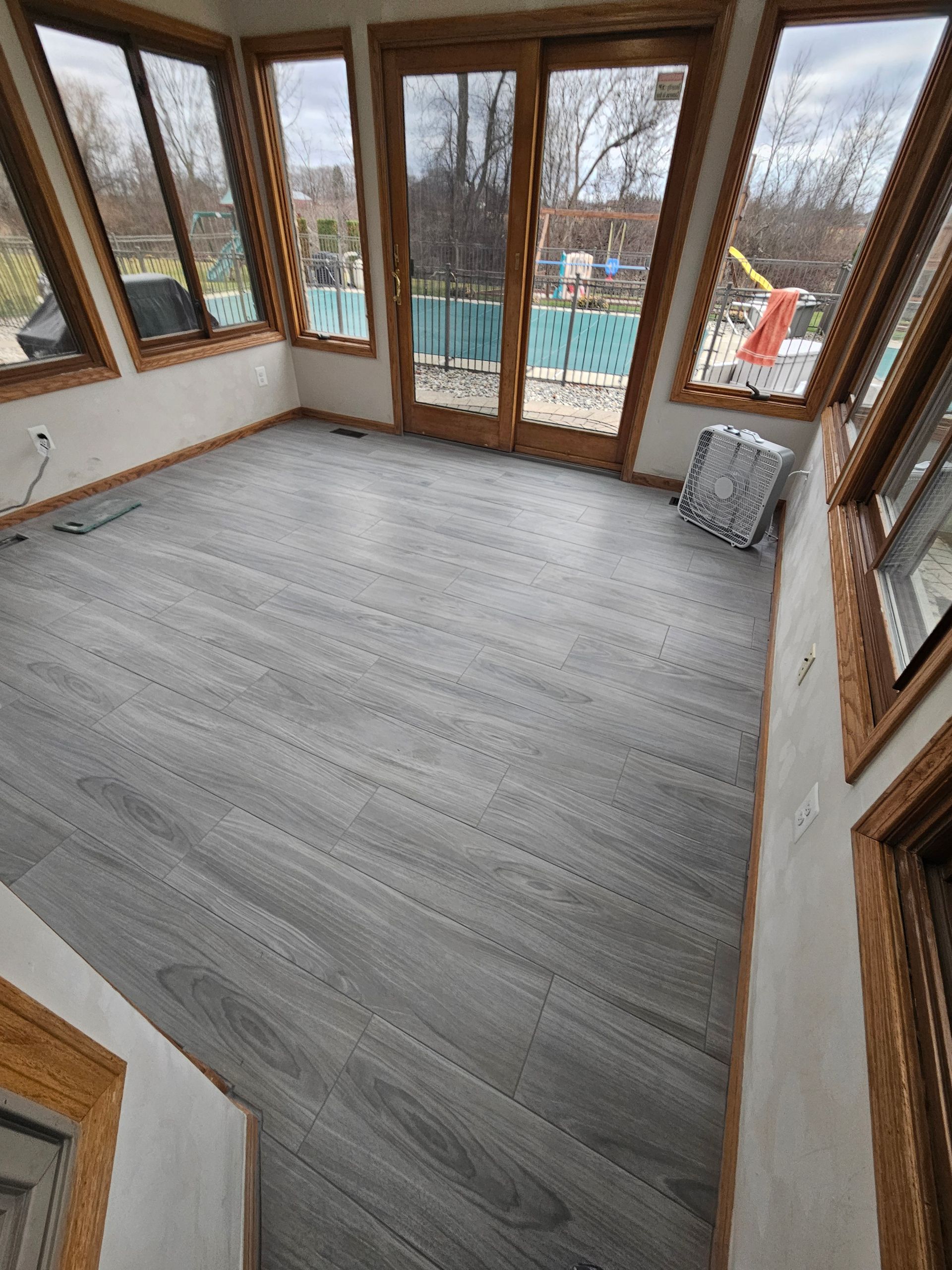 A room with a lot of windows and a wooden floor.