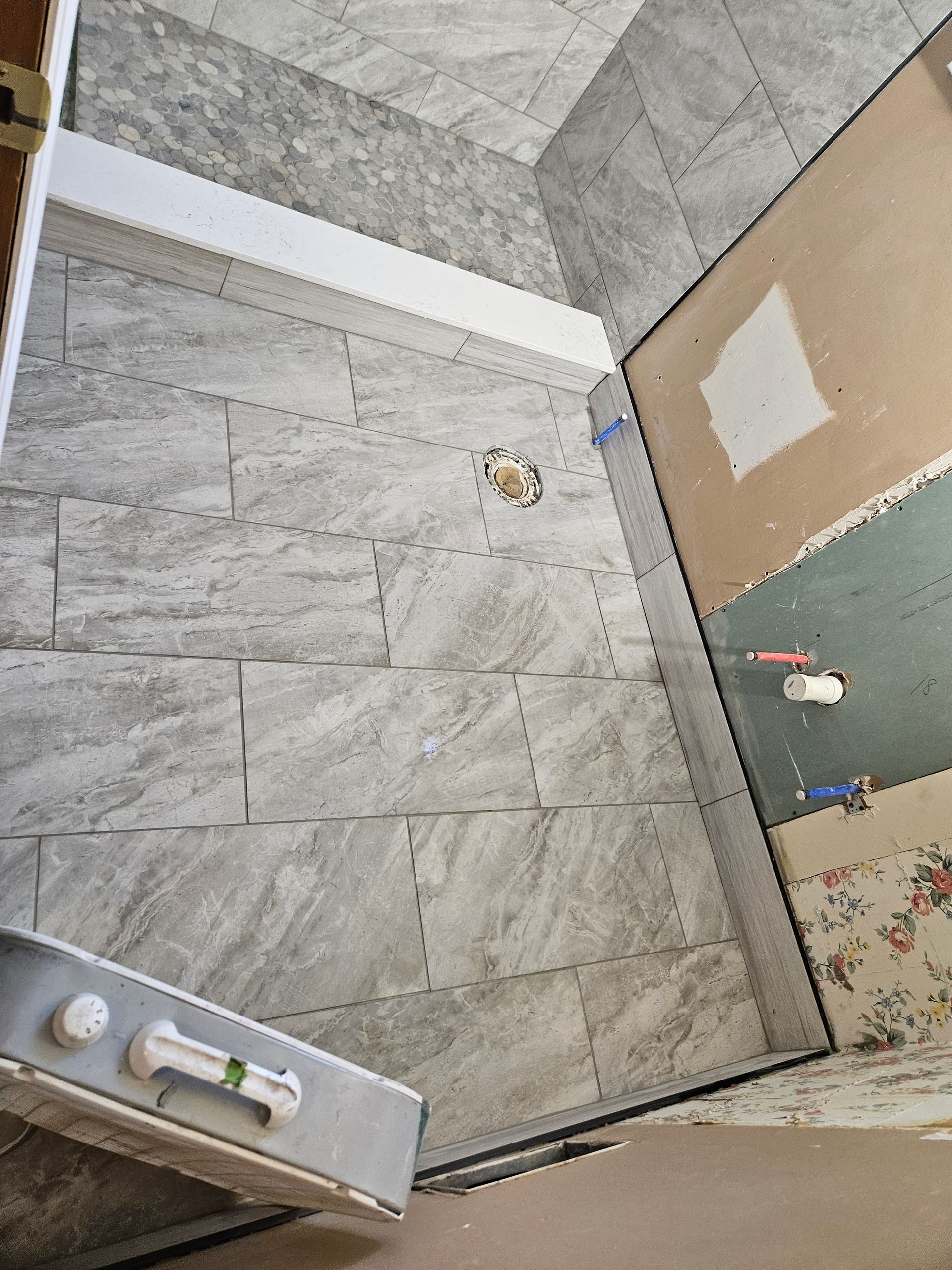 A room with tiles on the floor and a door.