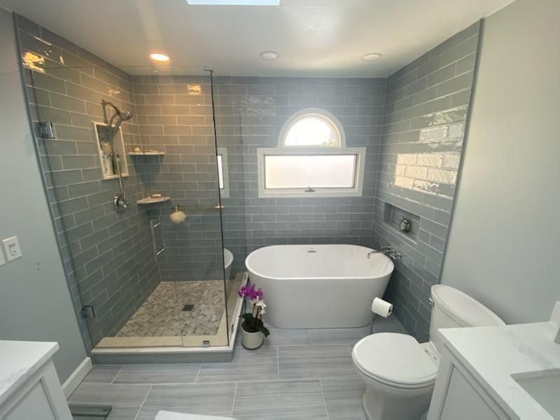 A bathroom with a tub , toilet , sink and shower.