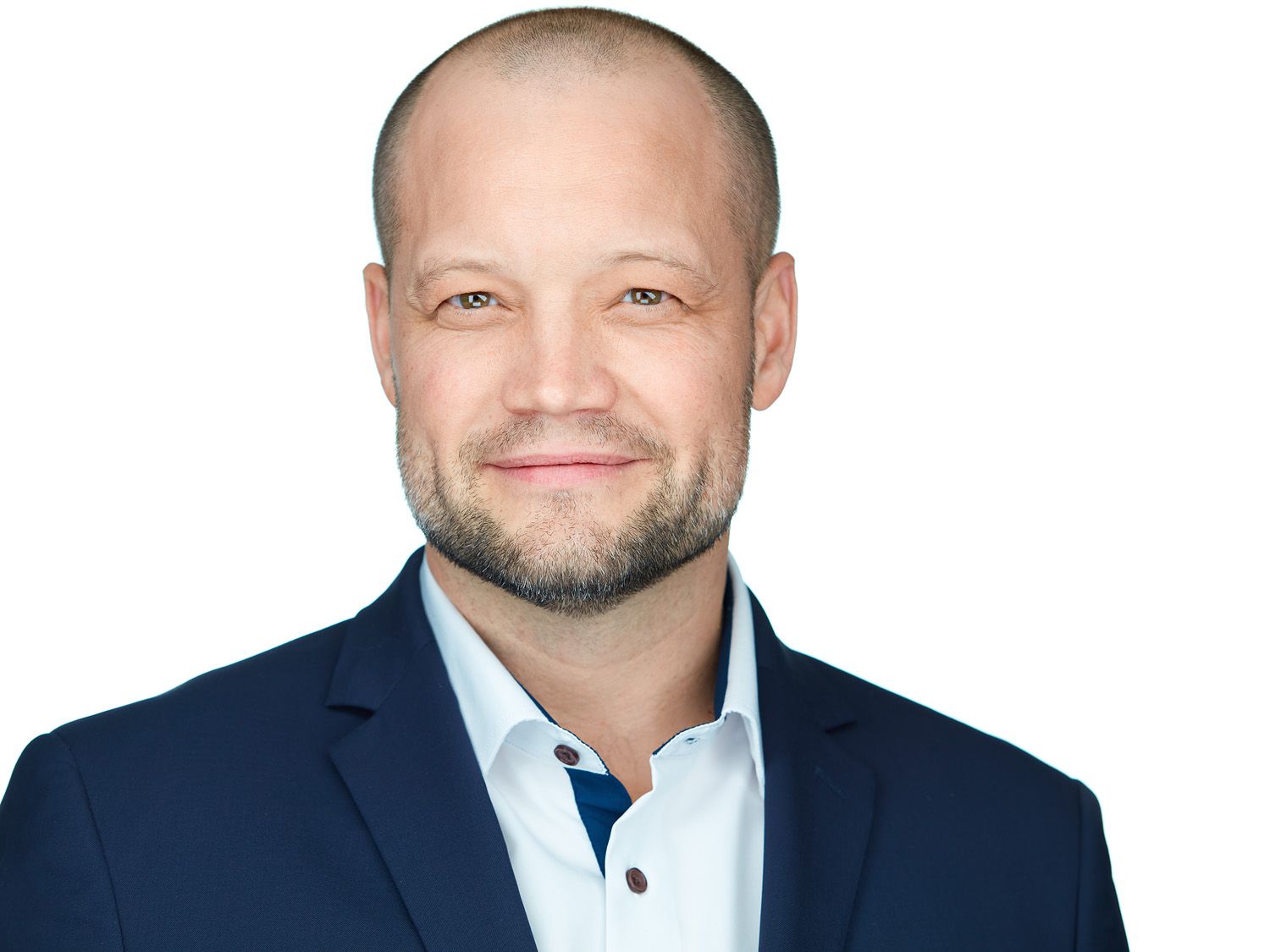 Man in blue blazer smiles, headshot.