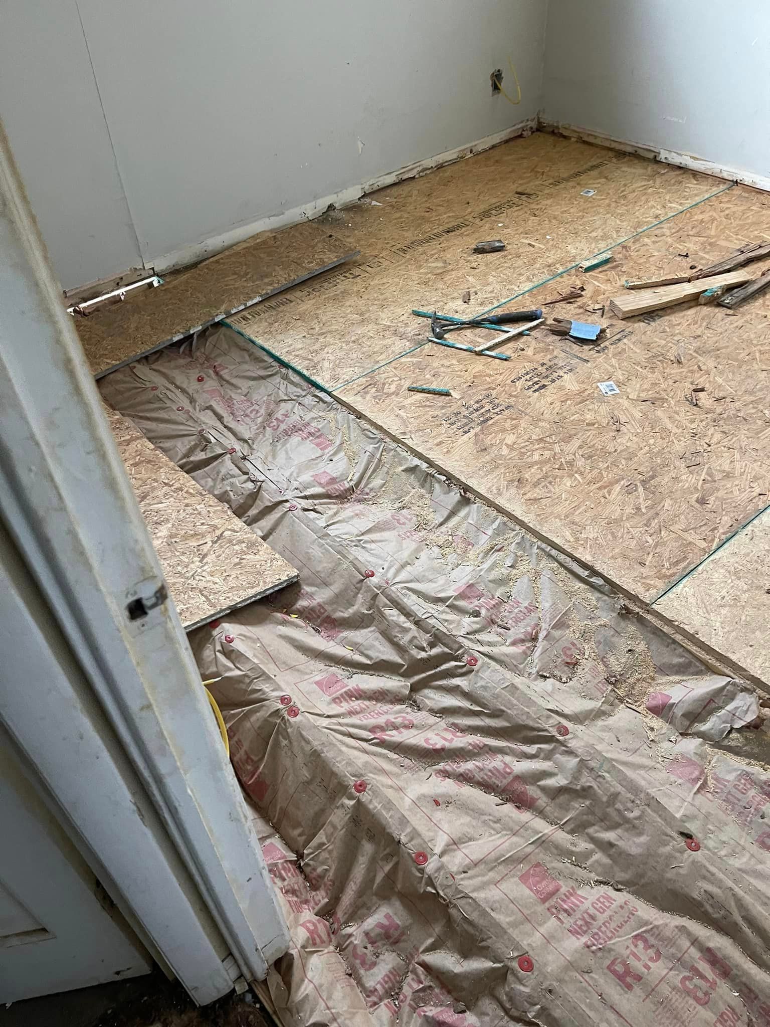 A room with a wooden floor being installed in it.