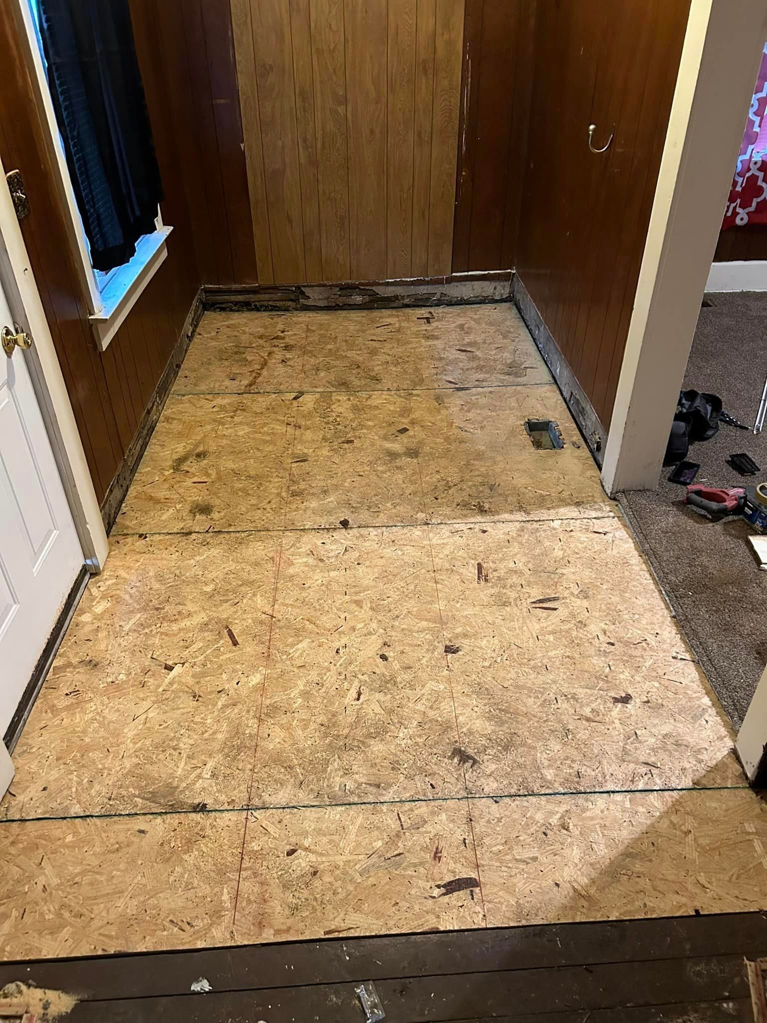 A room with a wooden floor and a wooden door.