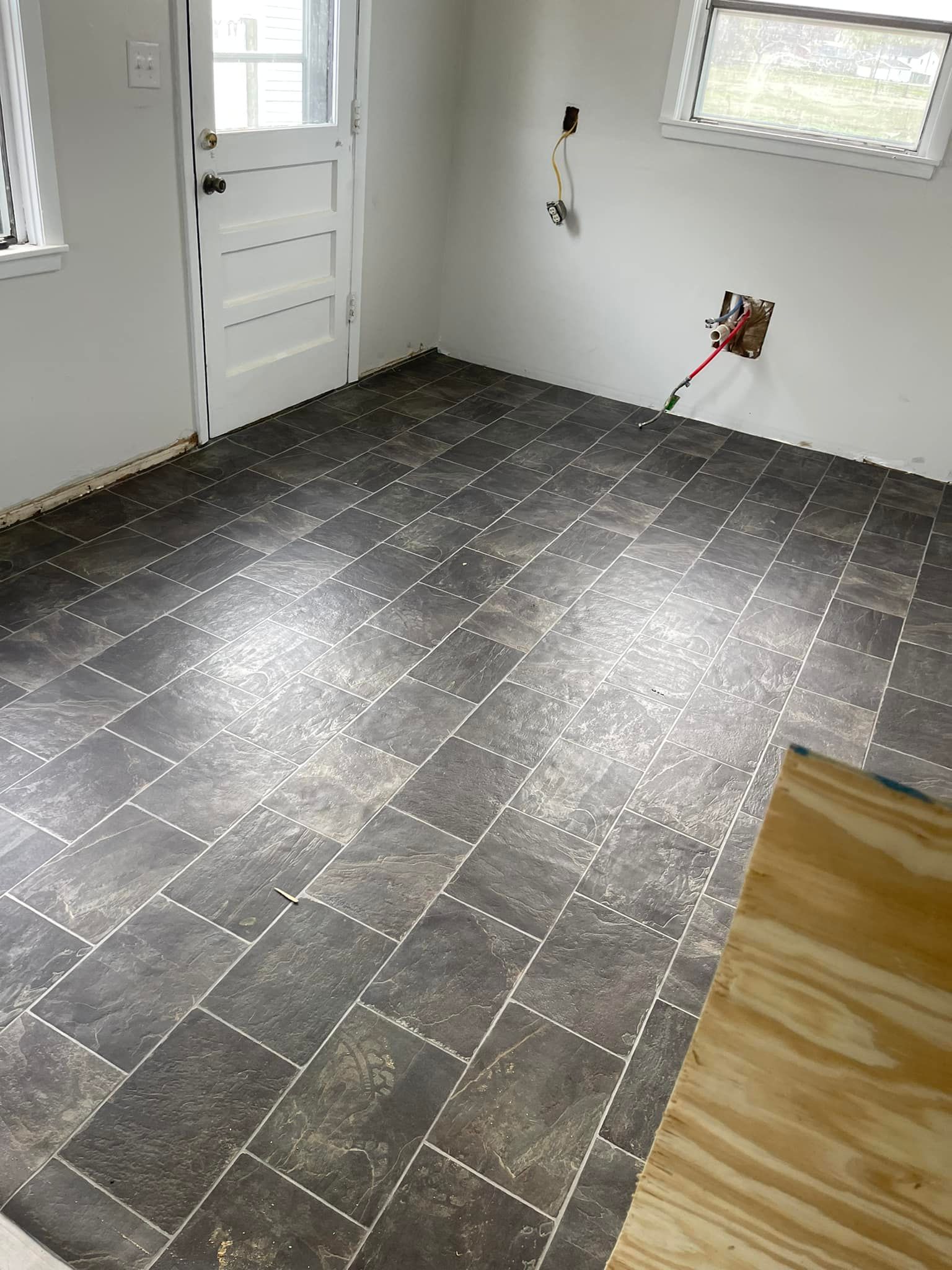 A room with a tiled floor and a window.