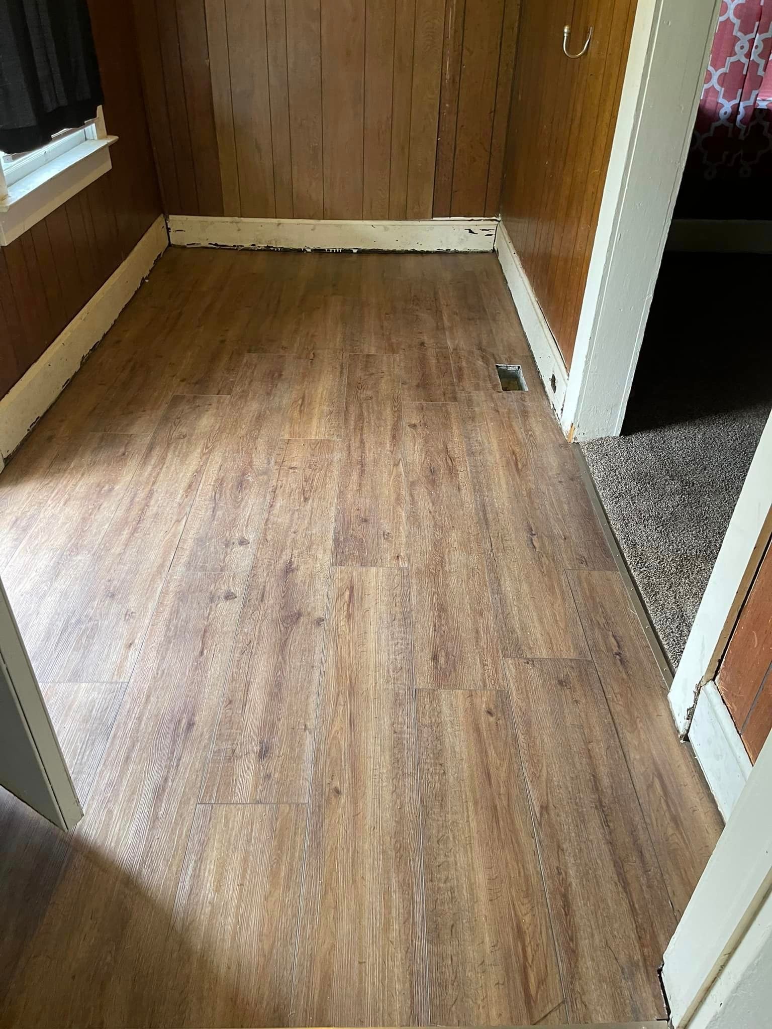 A room with a wooden floor and a window.