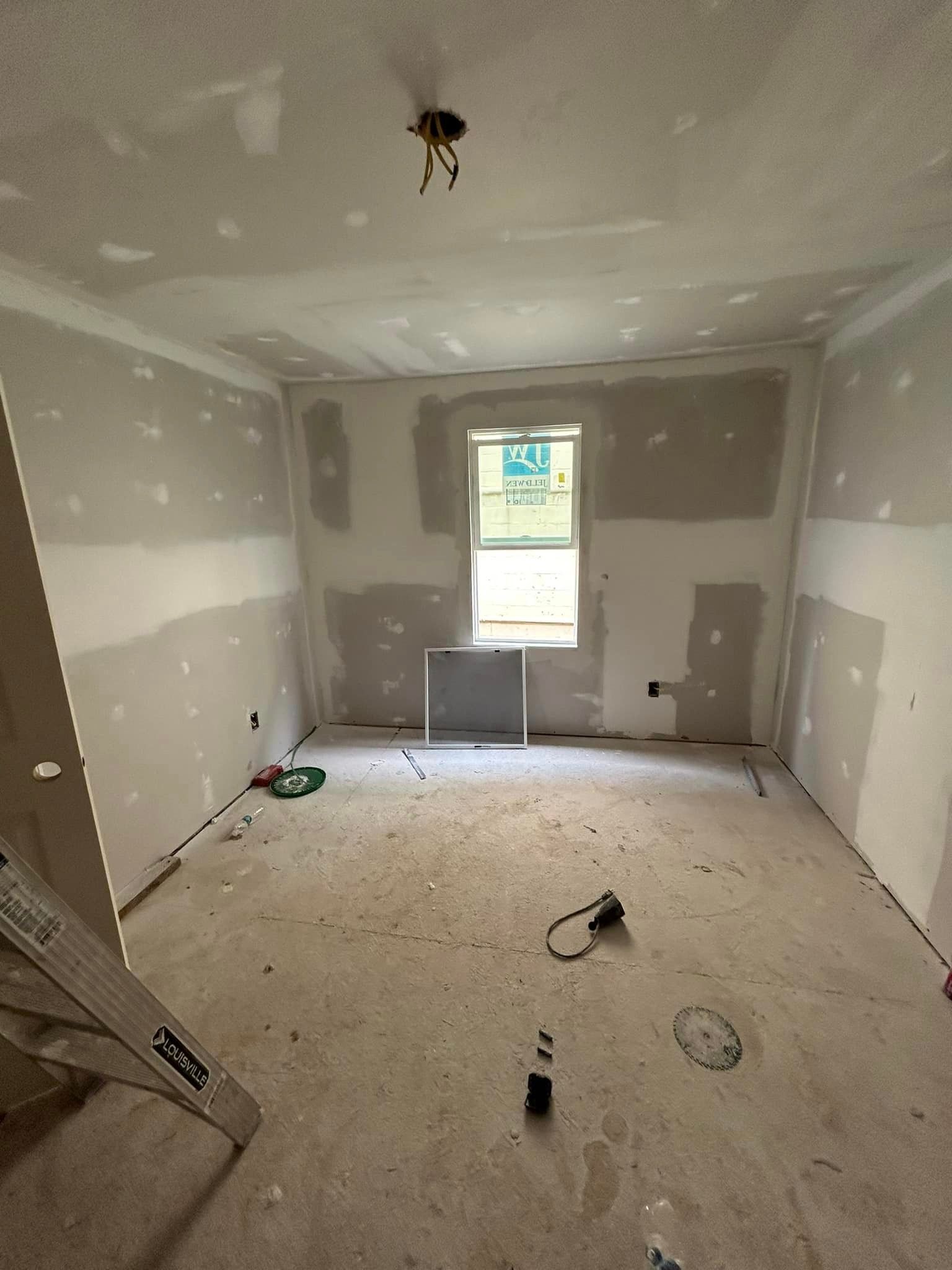 A room that is being remodeled with drywall and a window.