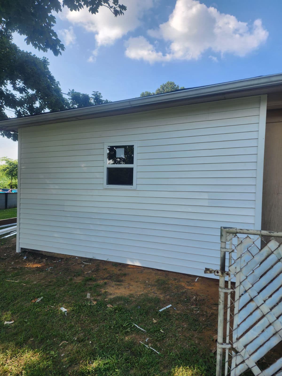 A white house with a window on the side of it.