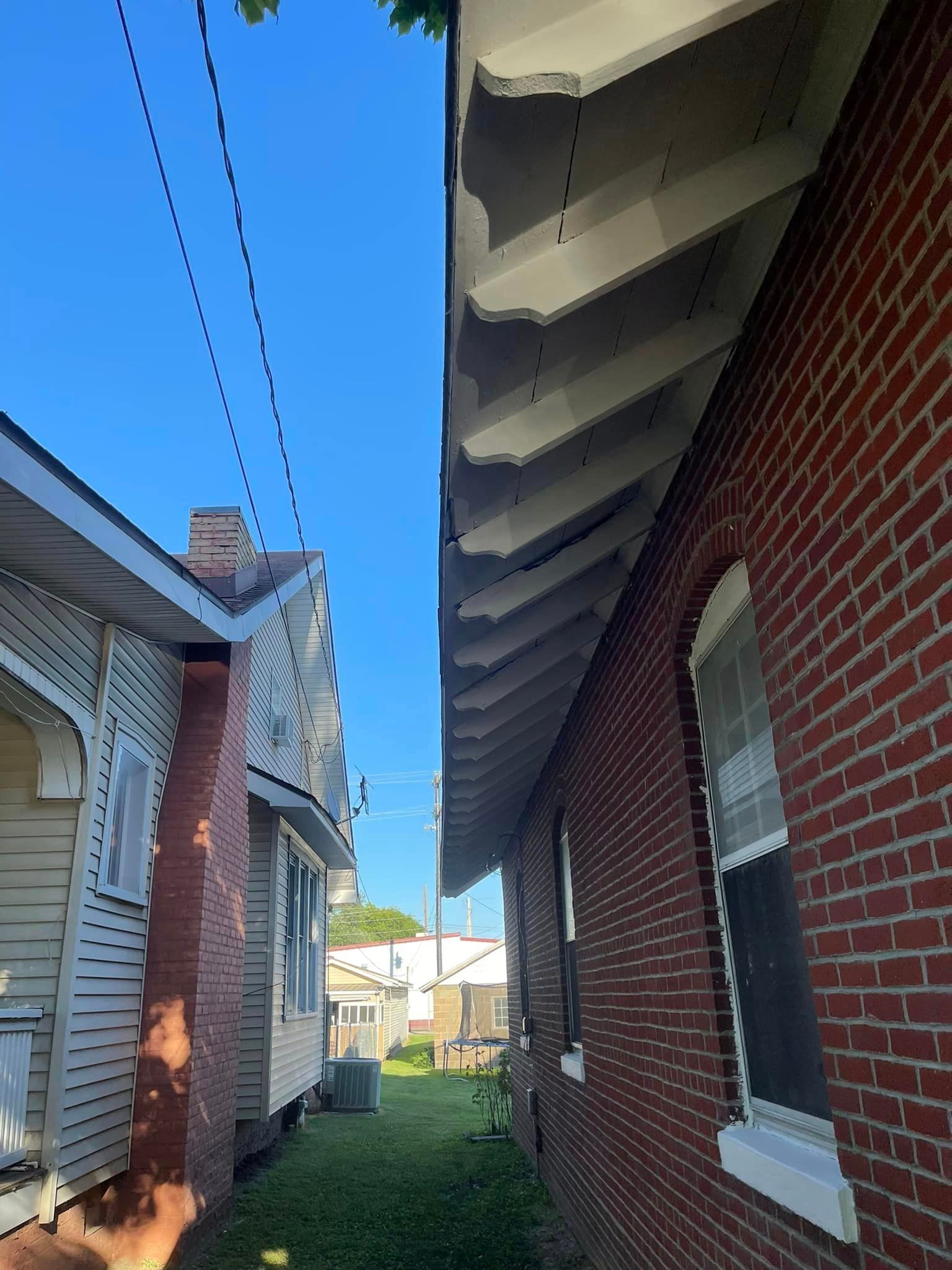 A brick building next to a white building with a blue sky in the background