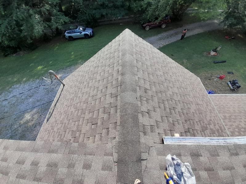 An aerial view of a roof with a car parked in the background.