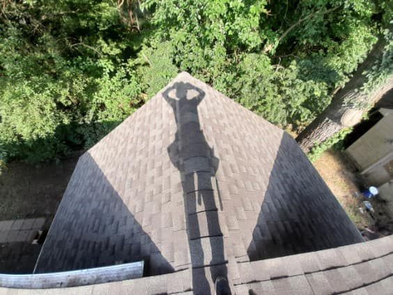 A shadow of a person is cast on the roof of a building