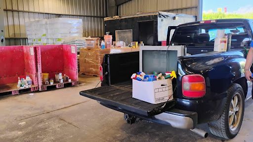 Move It or Lose It team loading paint cans and hazardous waste for safe recycling in Asheville, NC.