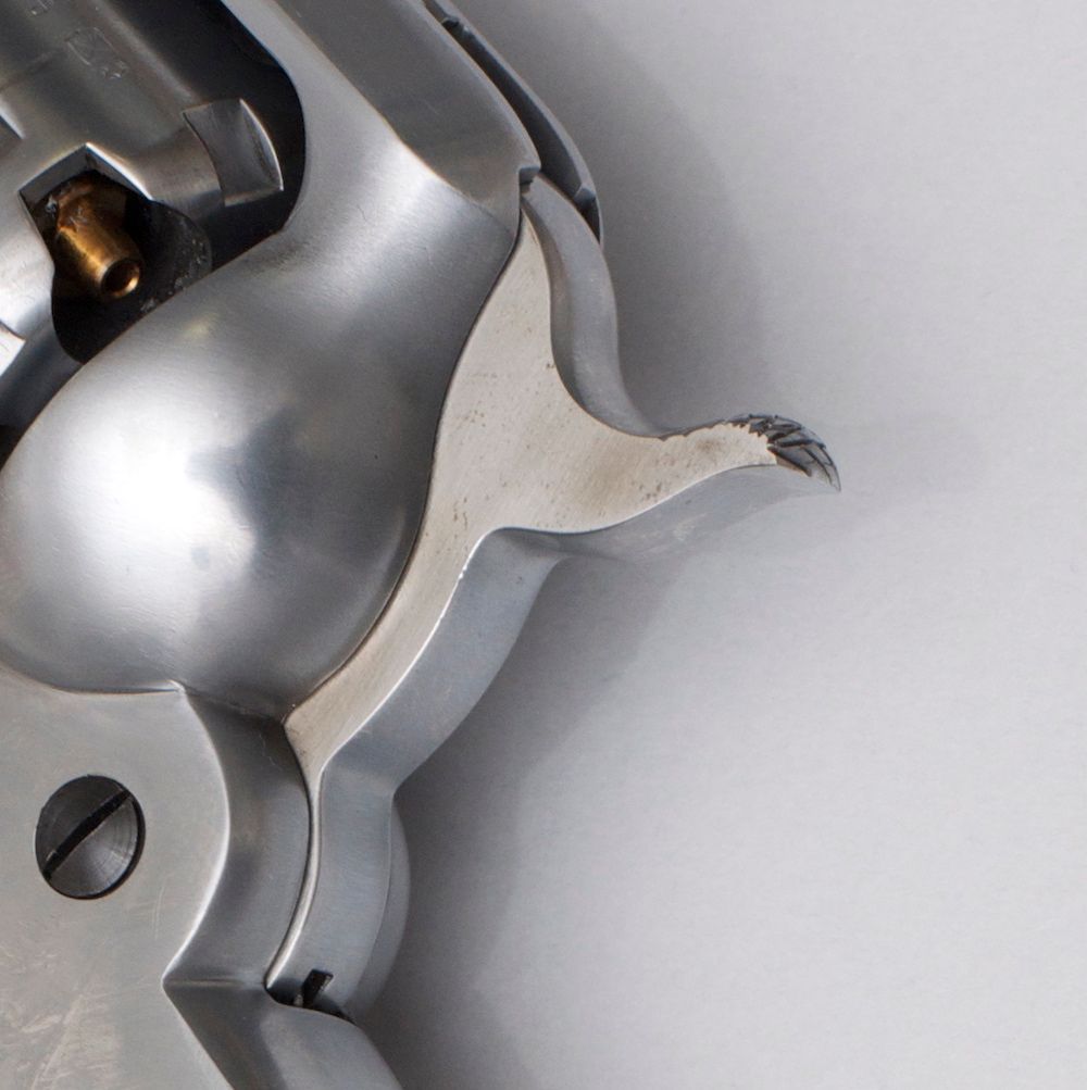 Revolver na črni smodnik z lesenim ročajem na beli podlagi.