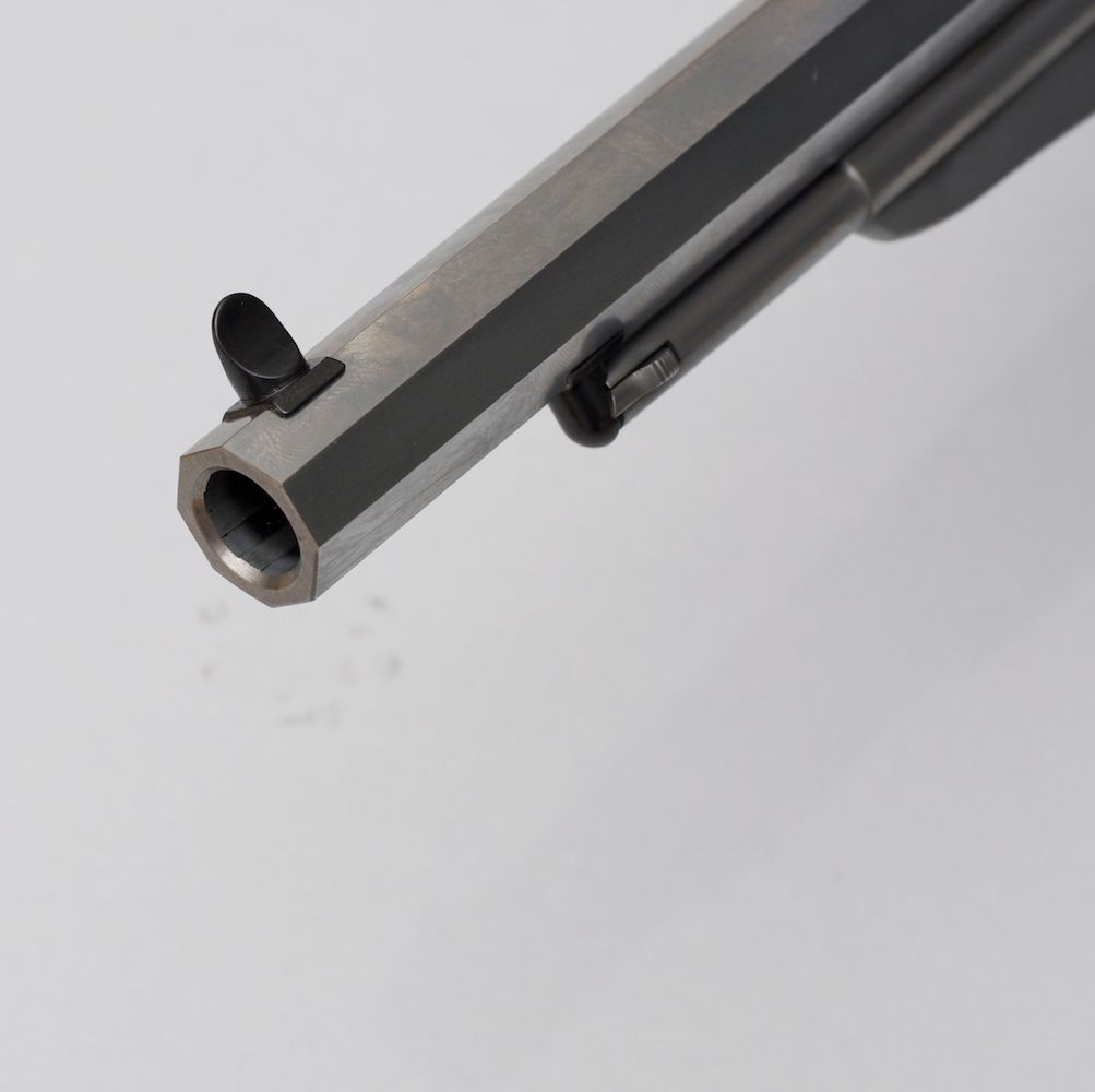 Revolver na črni smodnik z lesenim ročajem na beli podlagi.