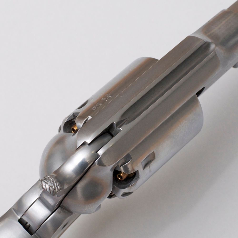 Revolver na črni smodnik z lesenim ročajem na beli podlagi.