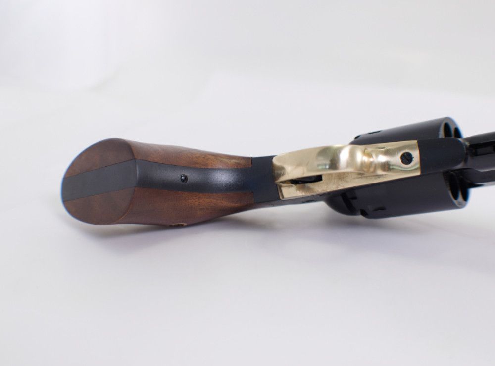 Revolver na črni smodnik z lesenim ročajem na beli podlagi.