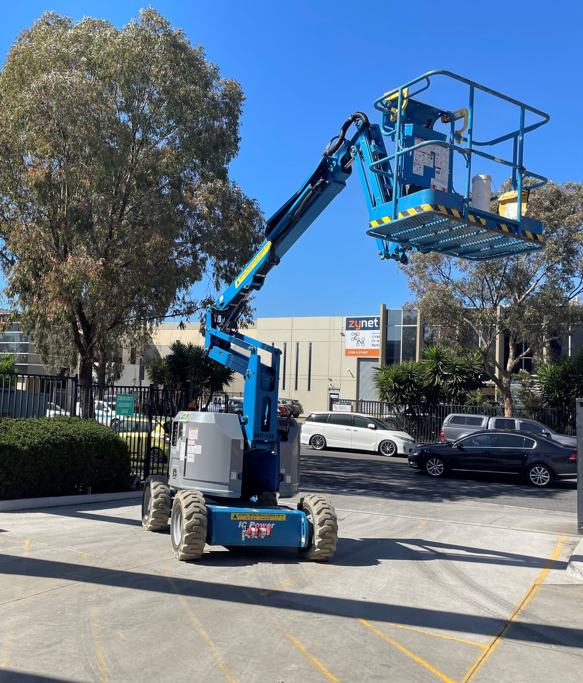 A blue and gray lift is parked in a parking lot