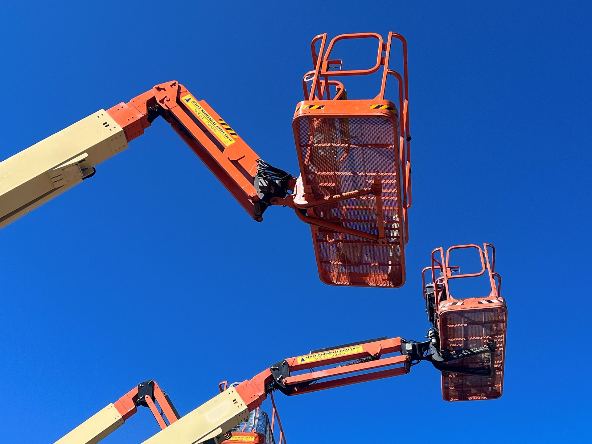 A red and black scissor lift is parked in a garage.