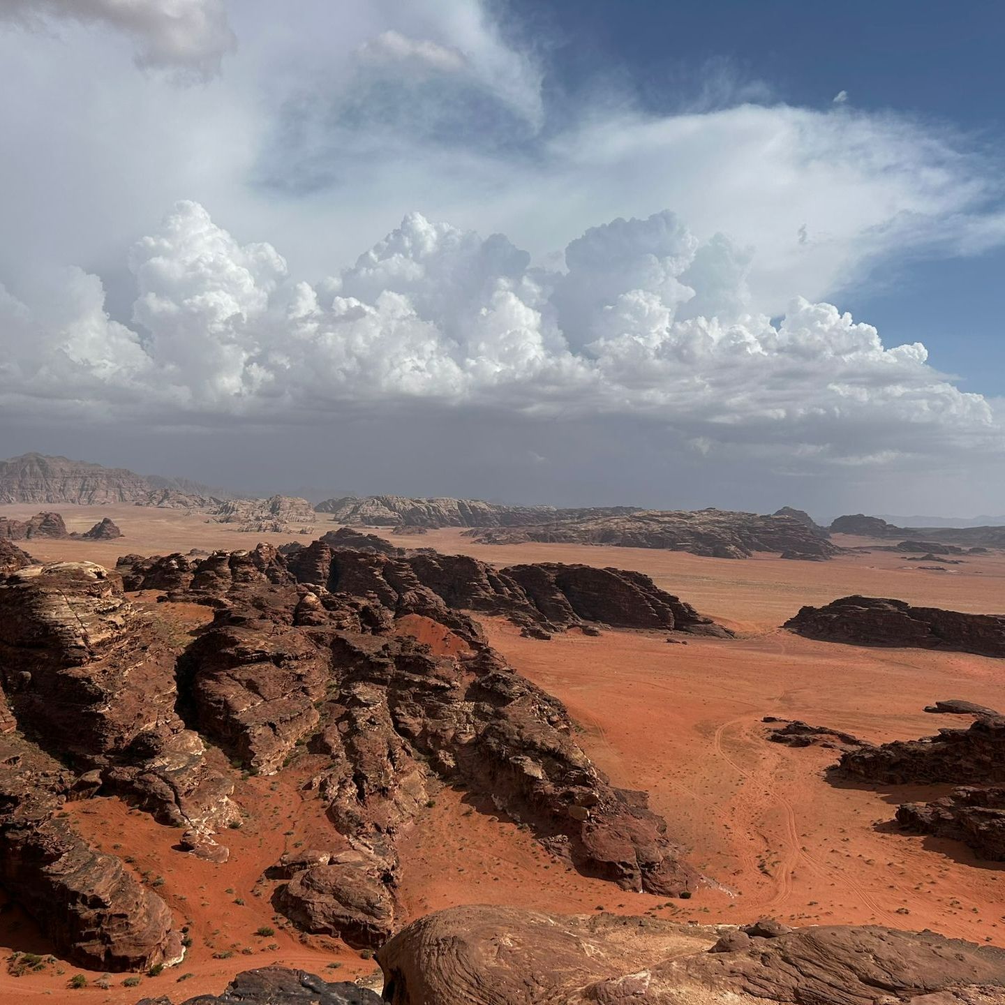 A desert landscape in Wadi Rum with rocks and clouds in the sky