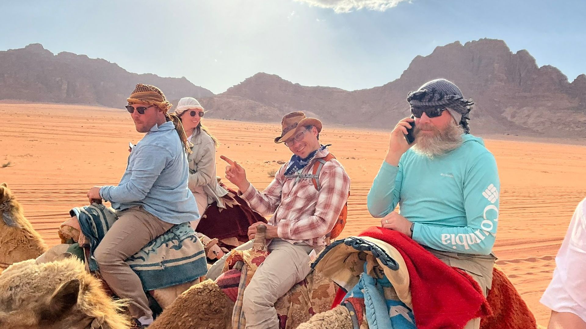 A group of people are riding camels in Wadi Rum