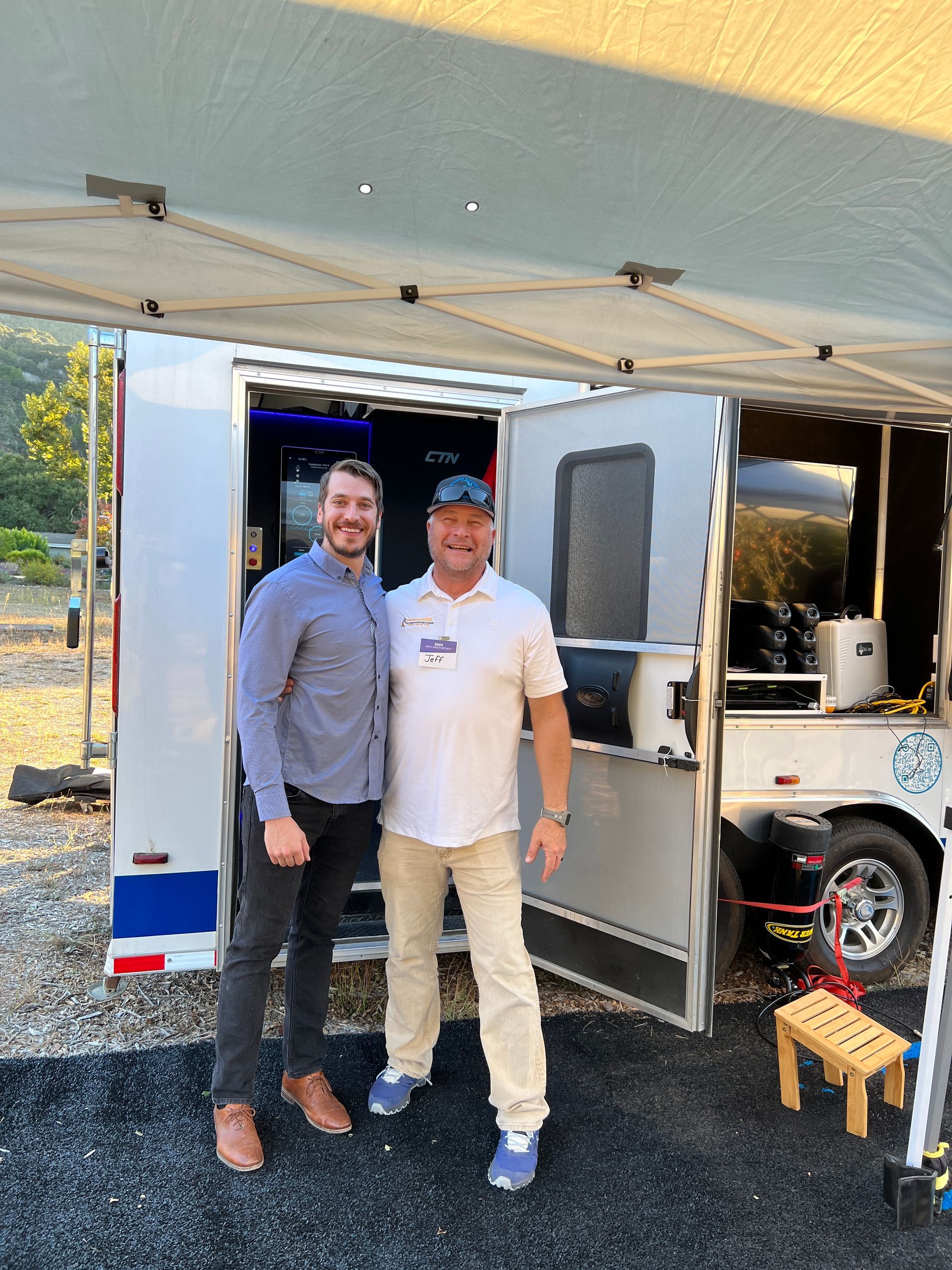 two men are posing for a picture in front of a trailer that's cryotherapy inside of it at an event called the cryo ranch 