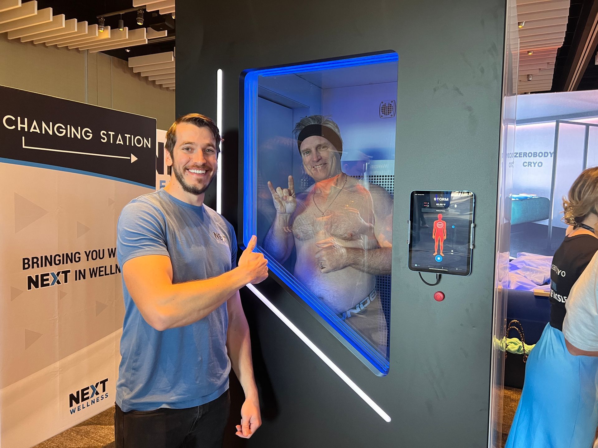A man is giving a thumbs up in front of a changing sign.