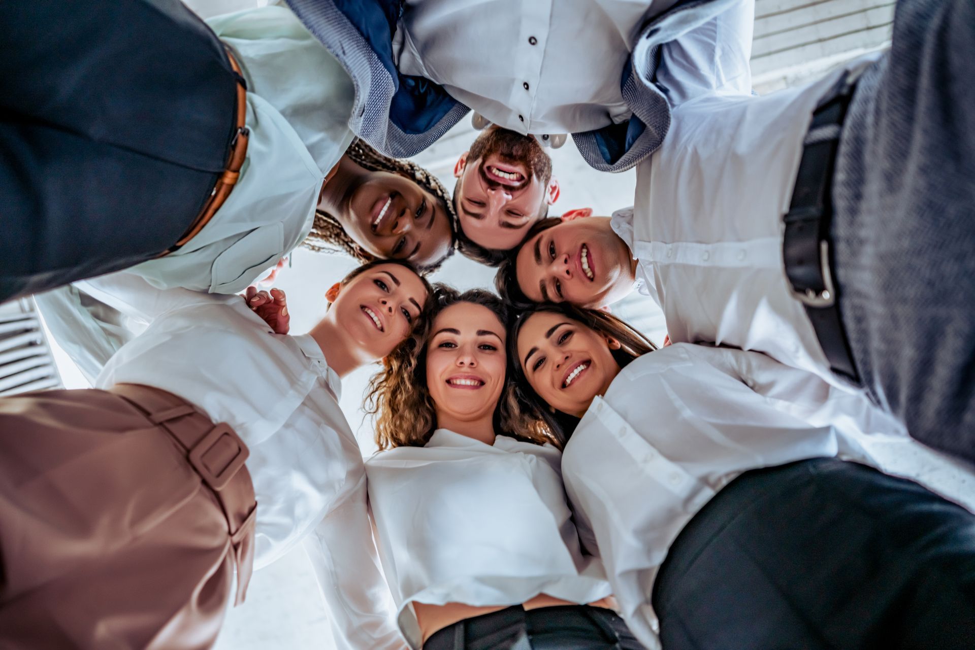 A woman is sitting in a chair with a laptop and talking on a cell phone.