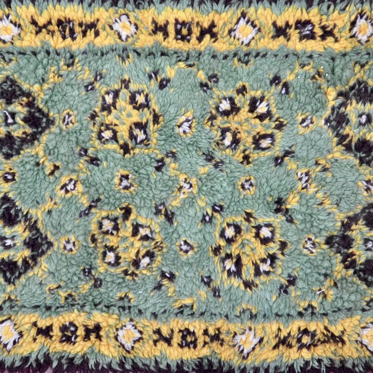 close-up of a blue, yellow, and black oriental shag rug