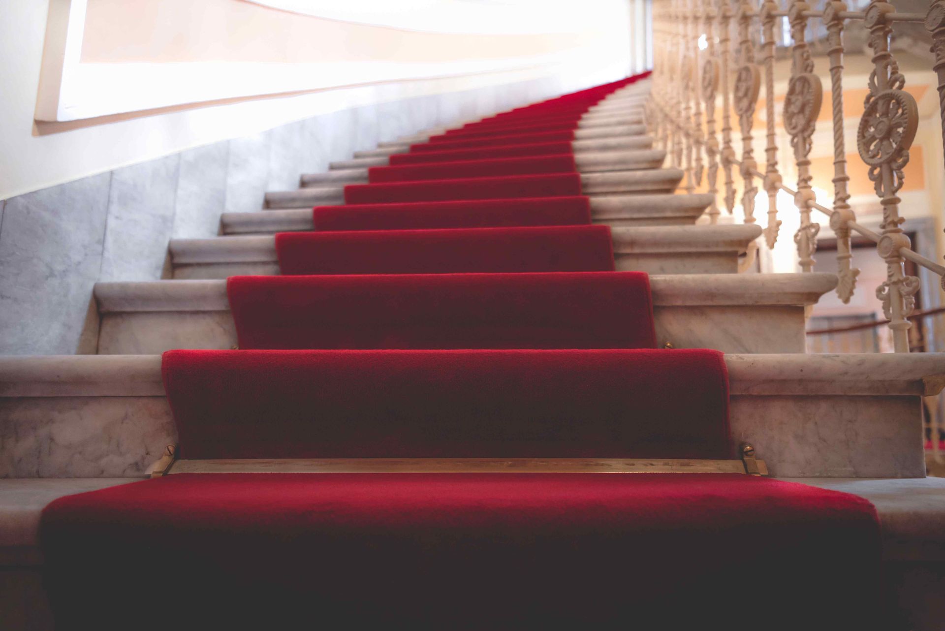 an elegant stairway covered with red carpet