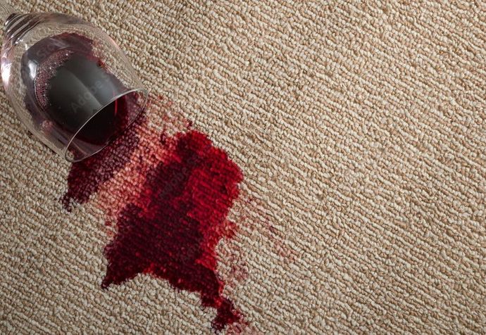 a wine glass that has been spilled on a carpet