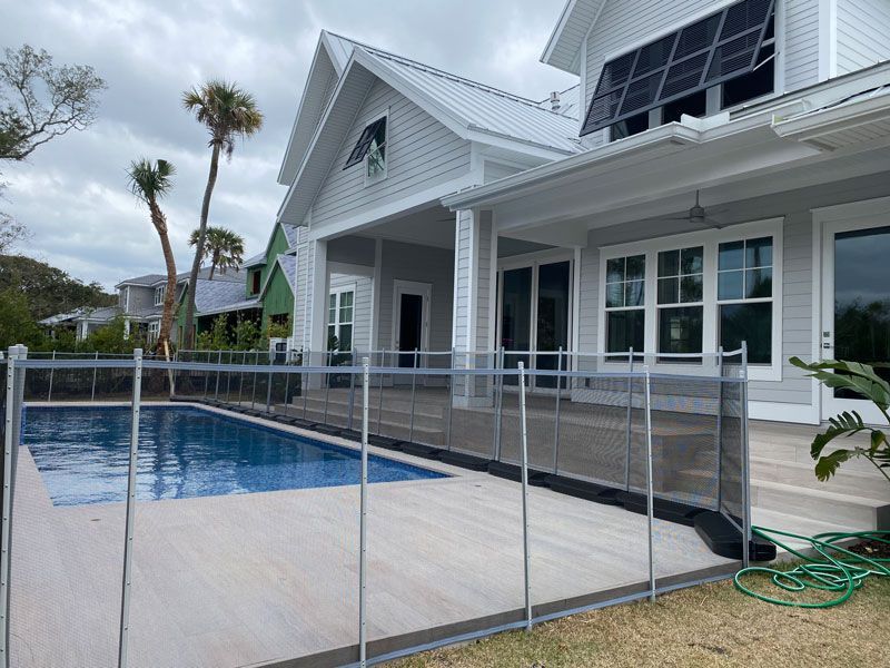 A large white house with a swimming pool in front of it.