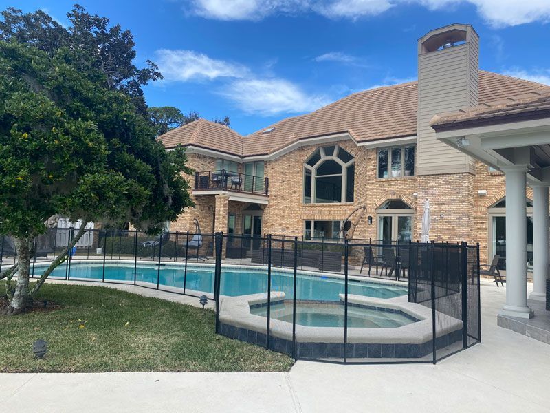 A large house with a swimming pool and a hot tub in the backyard.