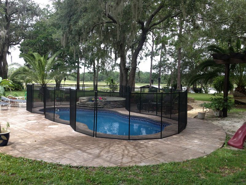 A pool with a fence around it and trees in the background