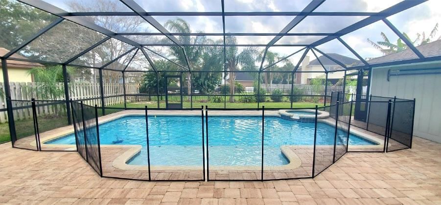 A large swimming pool with a screened in area and a fence around it.