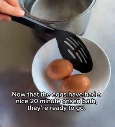 Two eggs in a white bowl, with tongs lifting them from a pot after an onsen bath.
