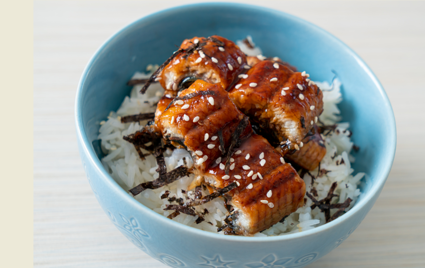 a blue bowl filled with rice and meat on a table .