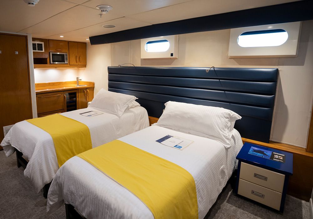 A bedroom with two twin beds and a nightstand.