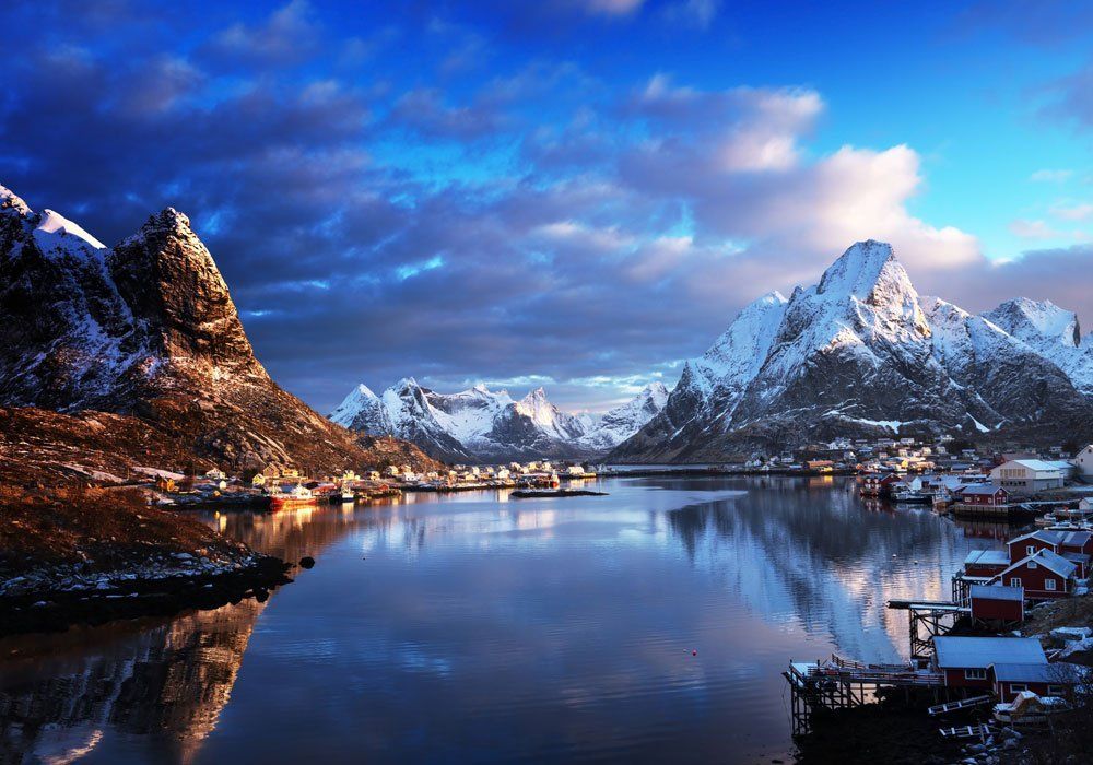 A lake with mountains in the background and boats in the foreground.