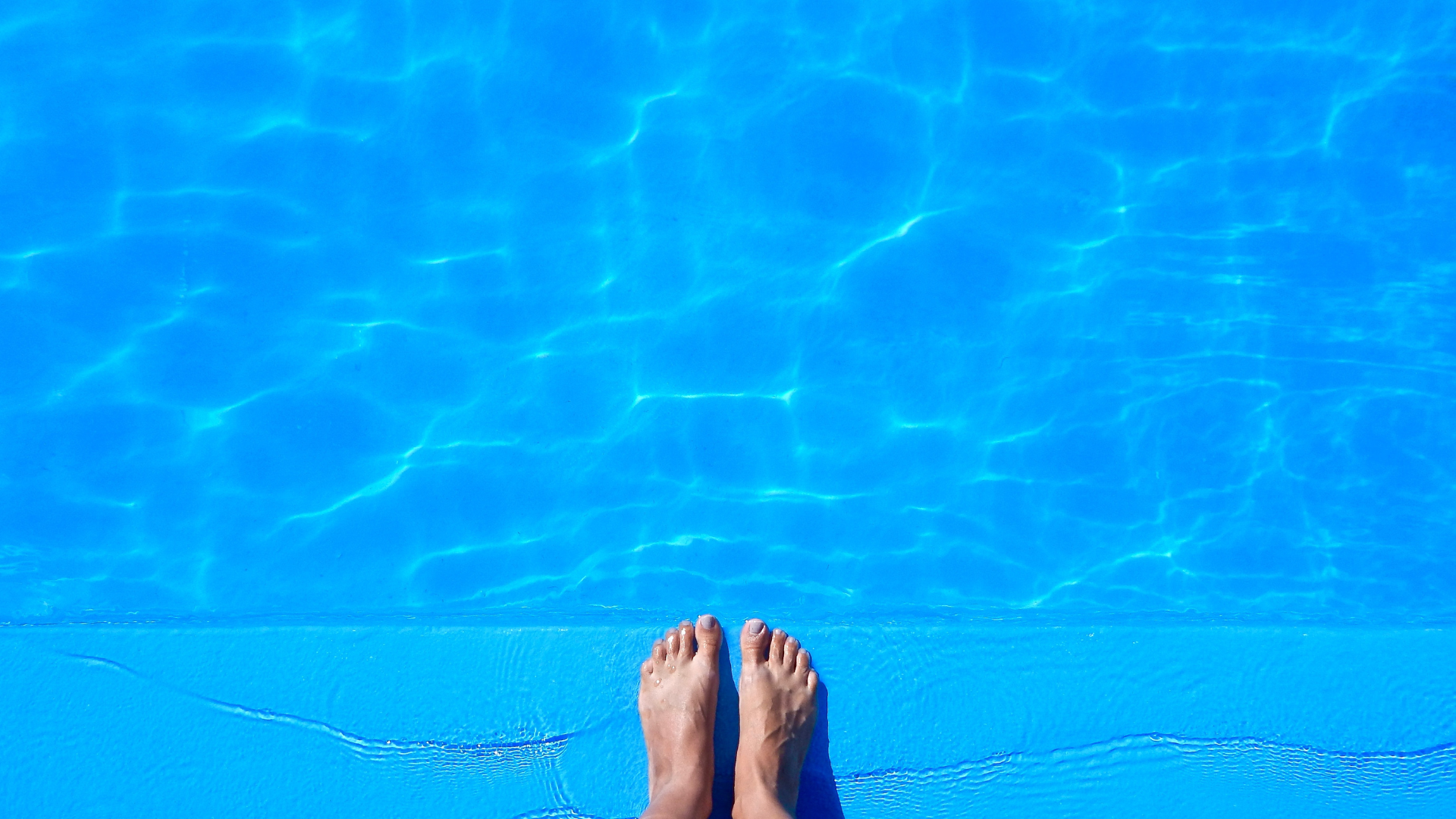 A swimming pool on a deck with a white railing
