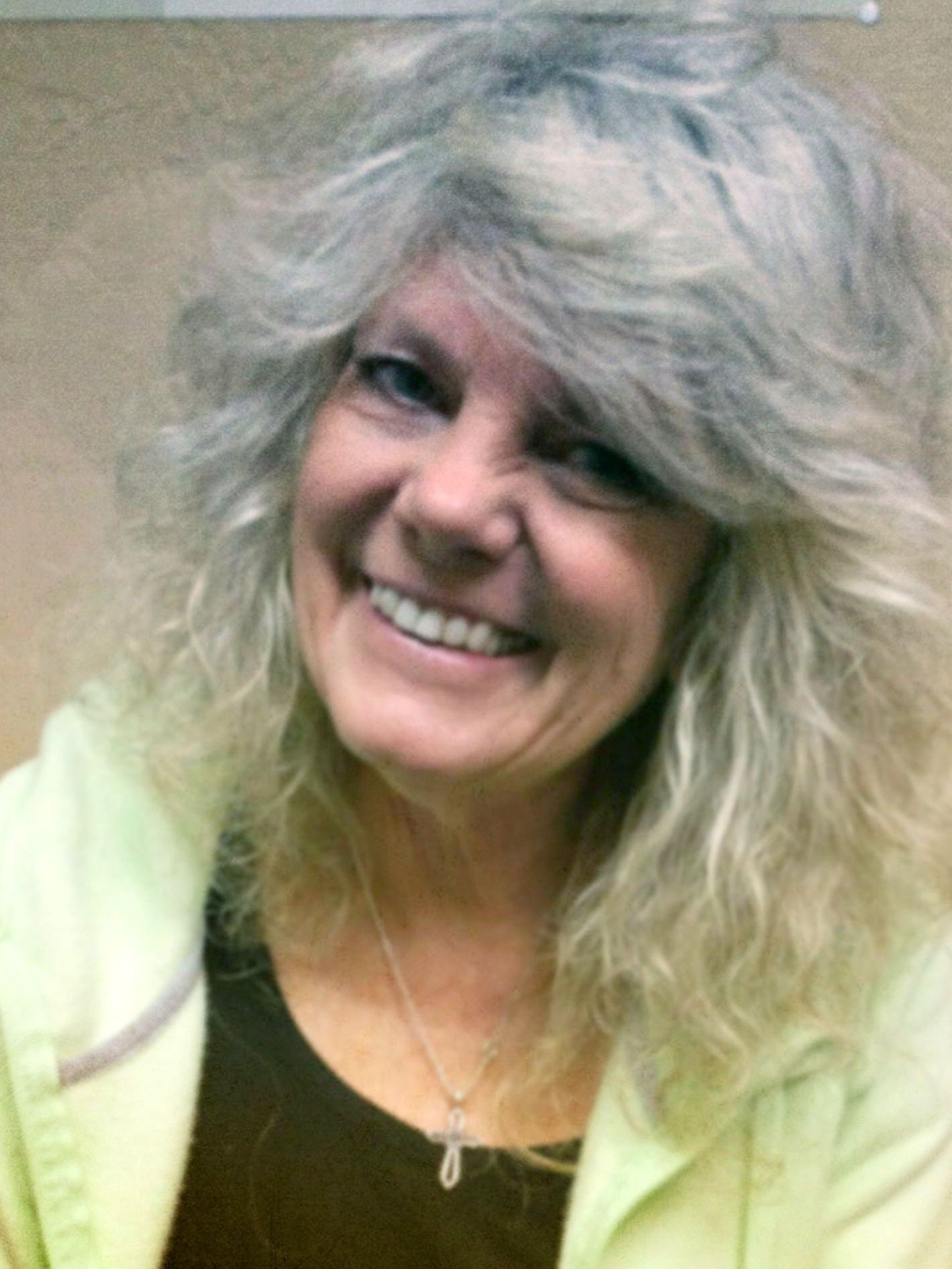 A woman with gray hair is smiling for the camera