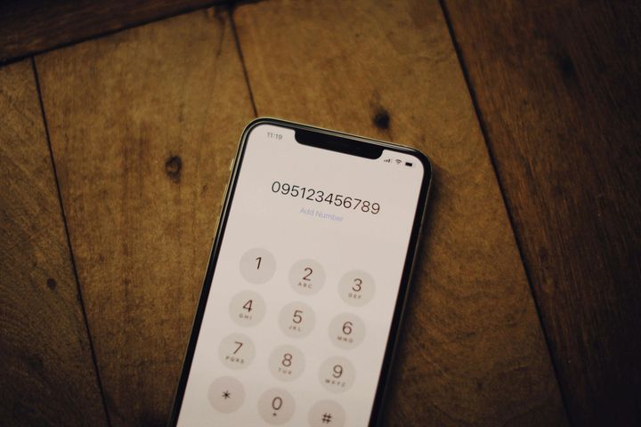 A cell phone is sitting on a wooden table.