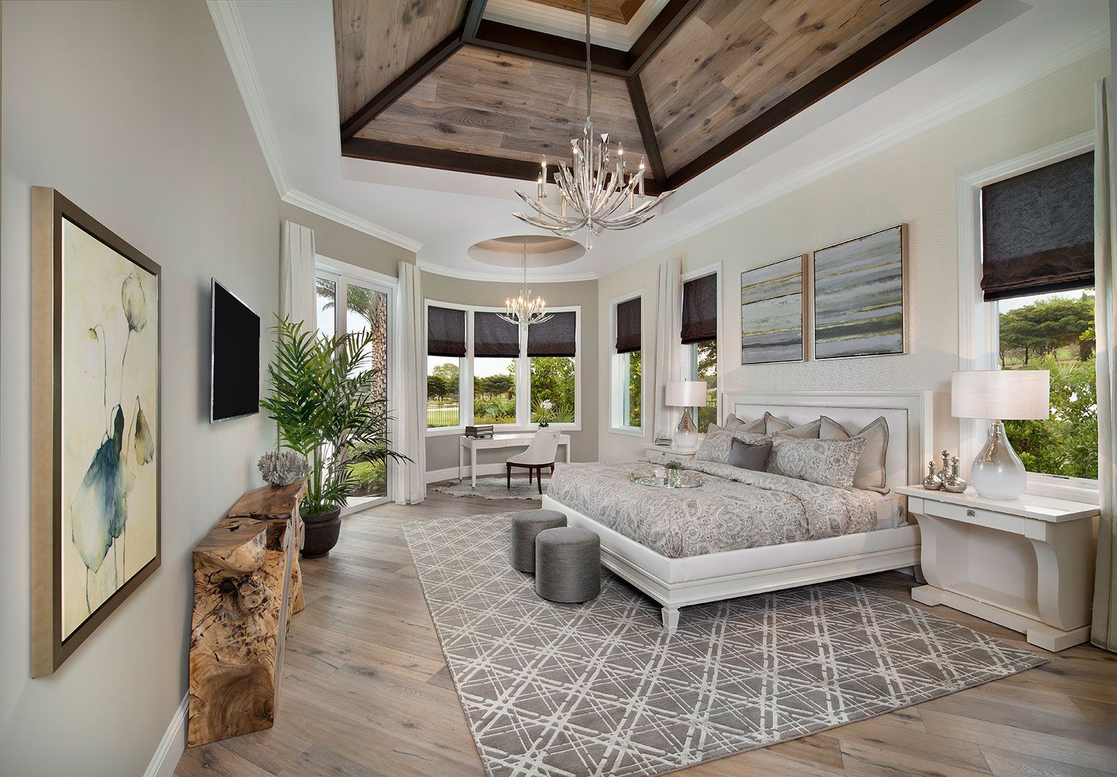 A large bedroom with a king size bed and a chandelier.